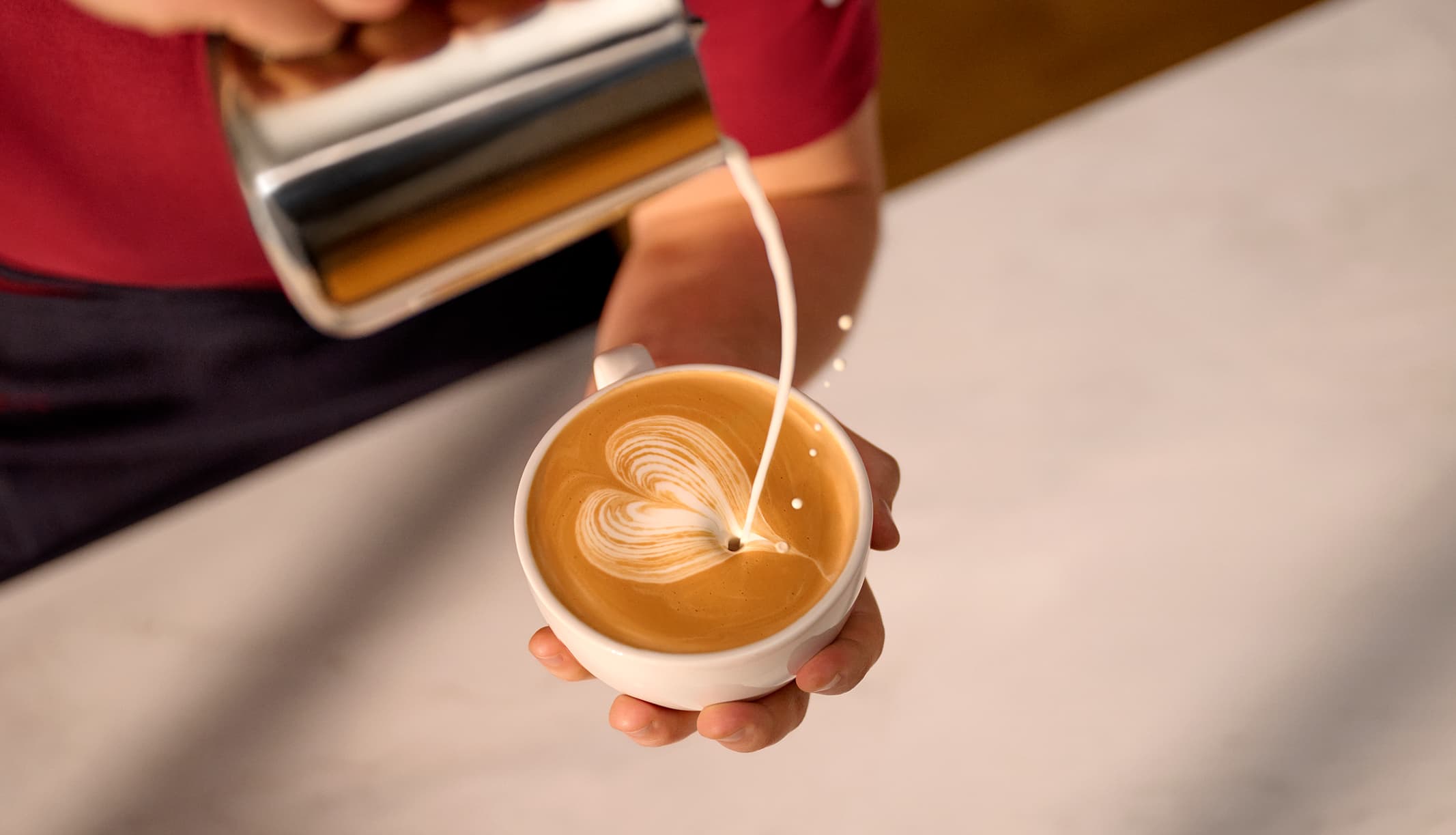 Pouring milk into hot drink