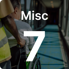 Person pushing another in a wheelchair down a brightly lit corridor. Large text reads "Misc 7" overlaying the image.