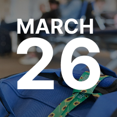 Text "March 26" over a blurred background of a waiting area with a blue bag and a patterned green ribbon in the foreground.