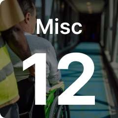 Person pushing another in a wheelchair along a corridor, with the text "Misc 12" overlayed in bold.