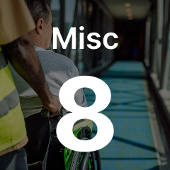 Person in a wheelchair is pushed through a corridor by another individual. The text "Misc 8" overlays the image.
