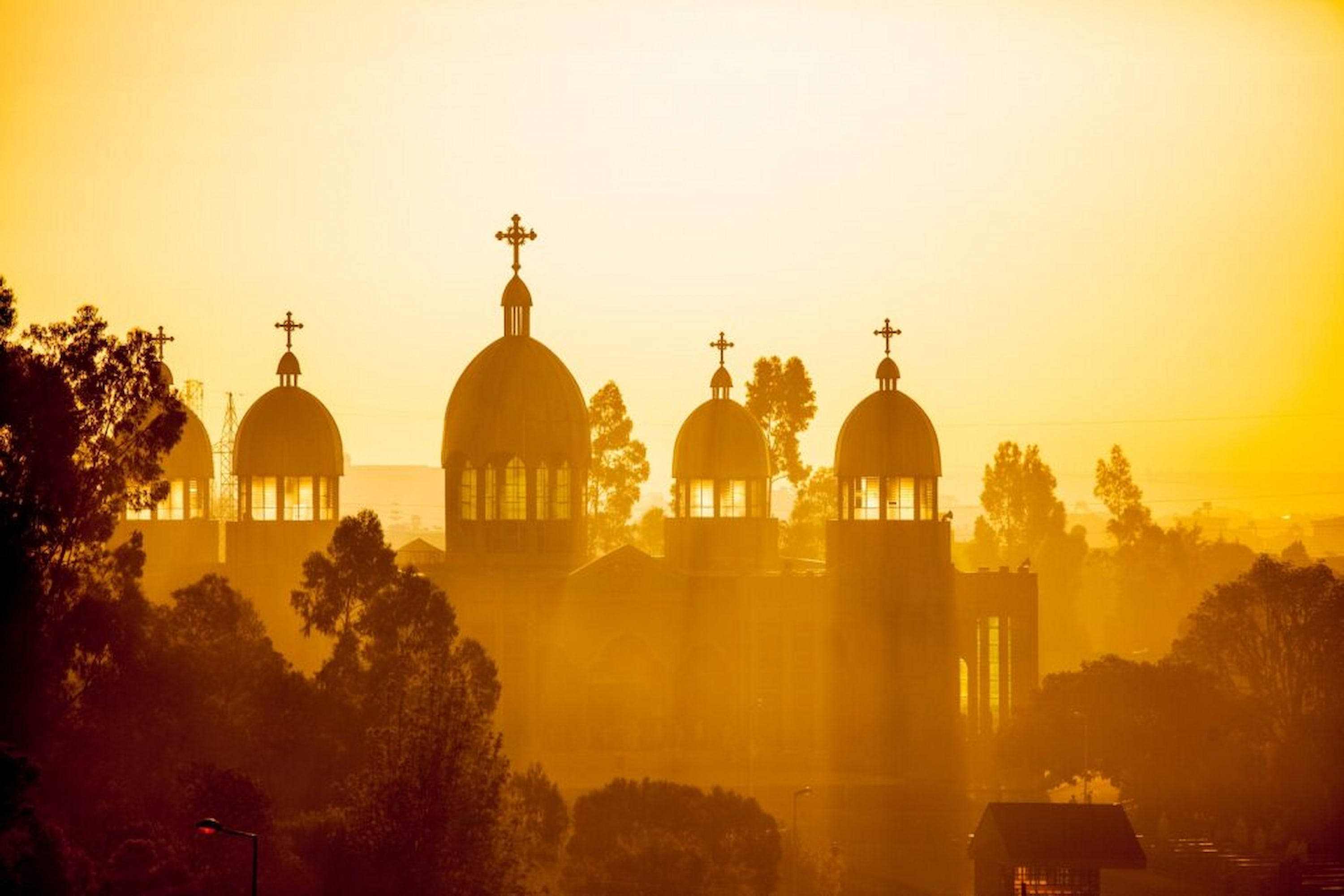Silhouetted domed church with crosses at sunset