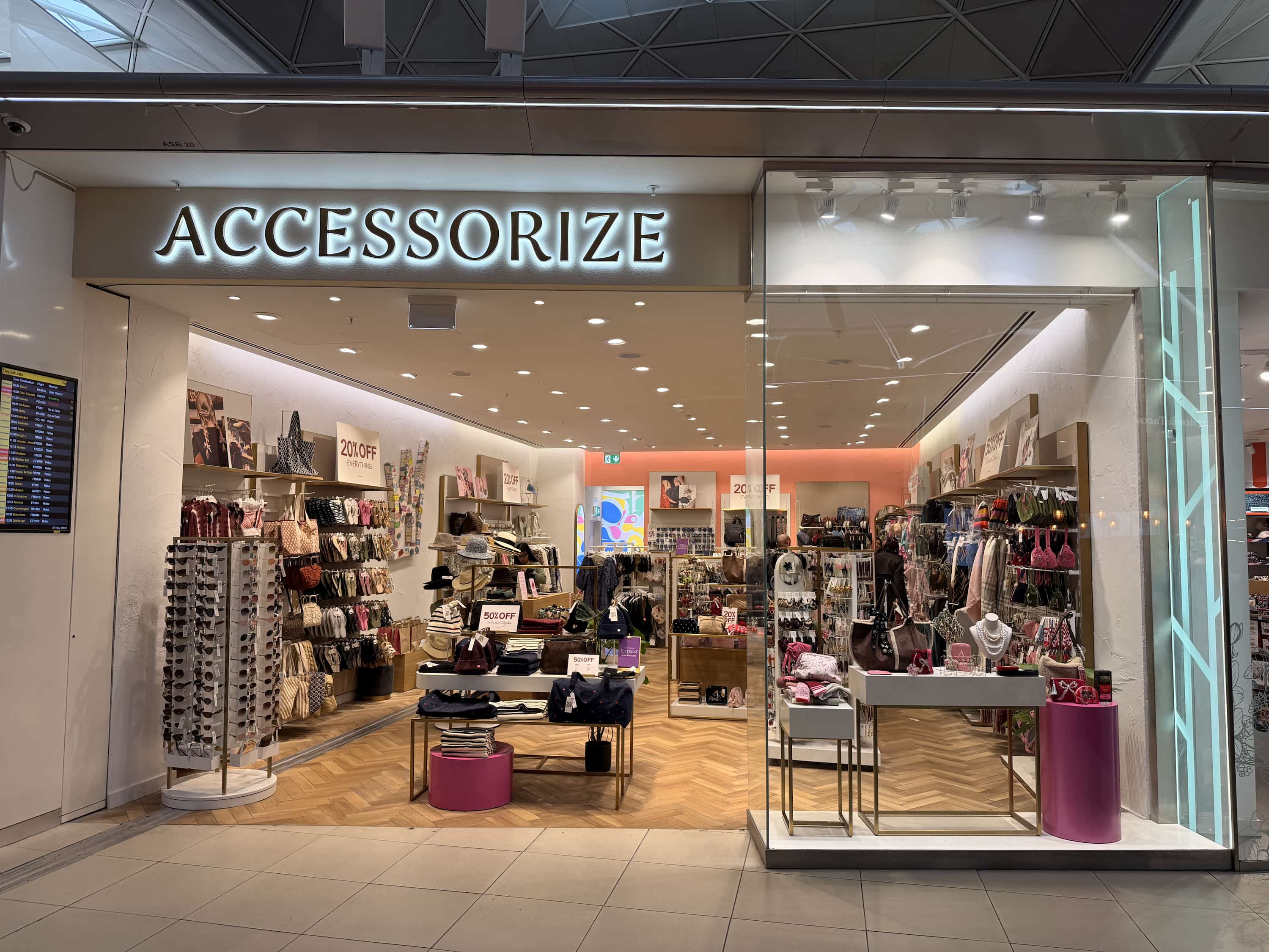 Storefront of Accessorize with handbags, accessories, and sale signs. Bright, well-lit interior with neatly organised displays.