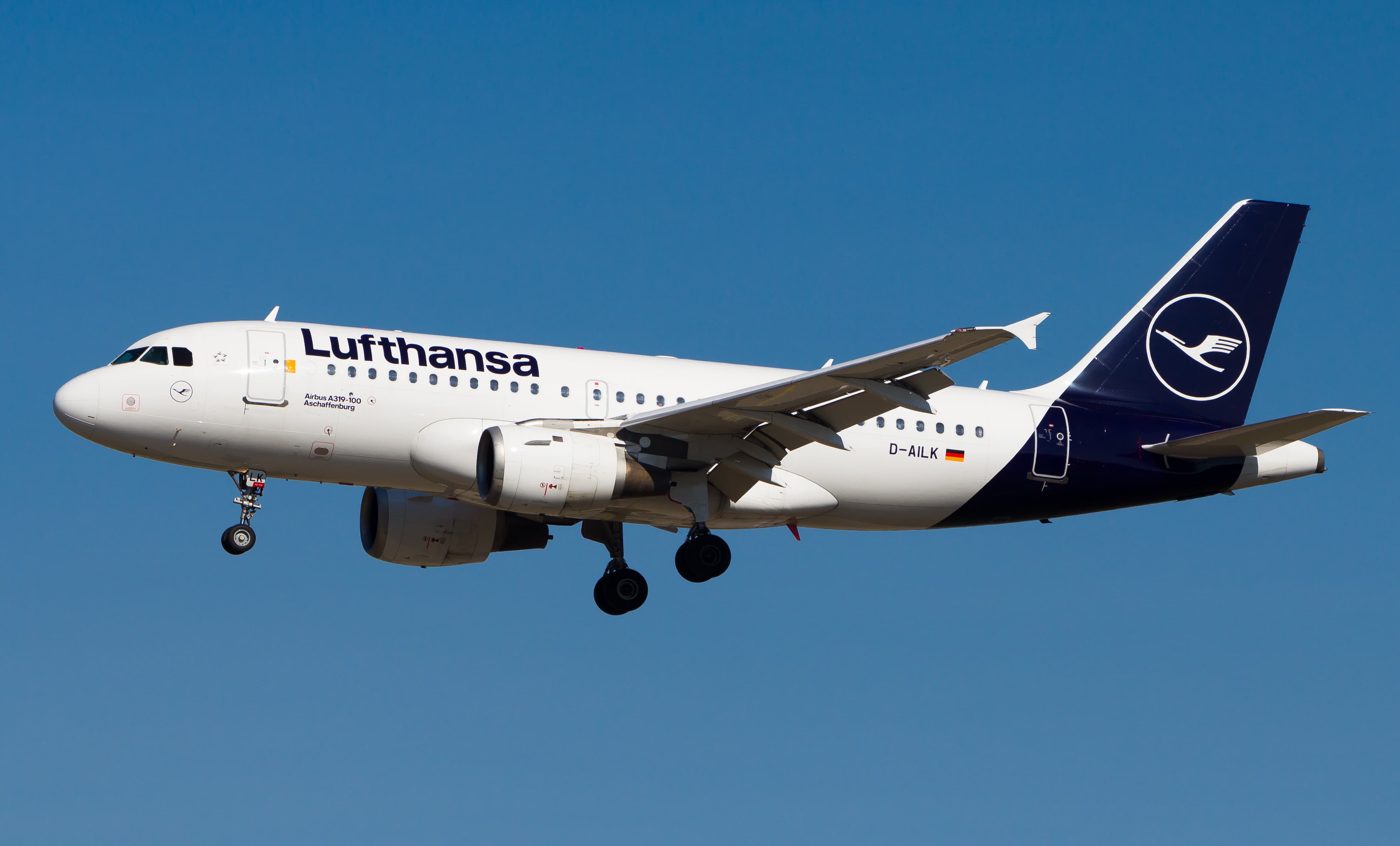 Lufthansa Airbus A319 aircraft in flight, clear blue sky backdrop.