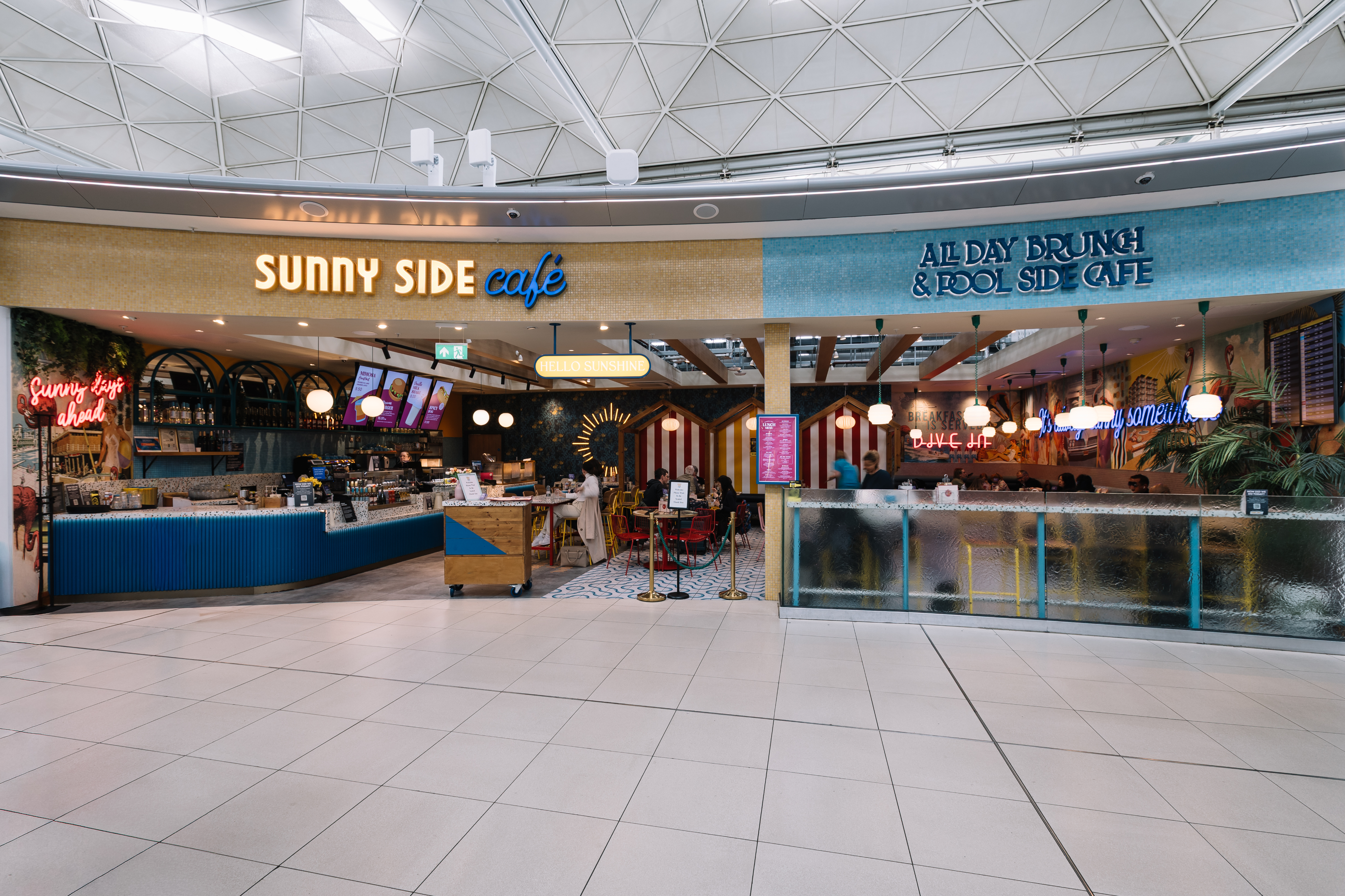 Sunny Side Café with colourful décor and neon lights offers all-day brunch and poolside vibes in a casual, inviting setting.