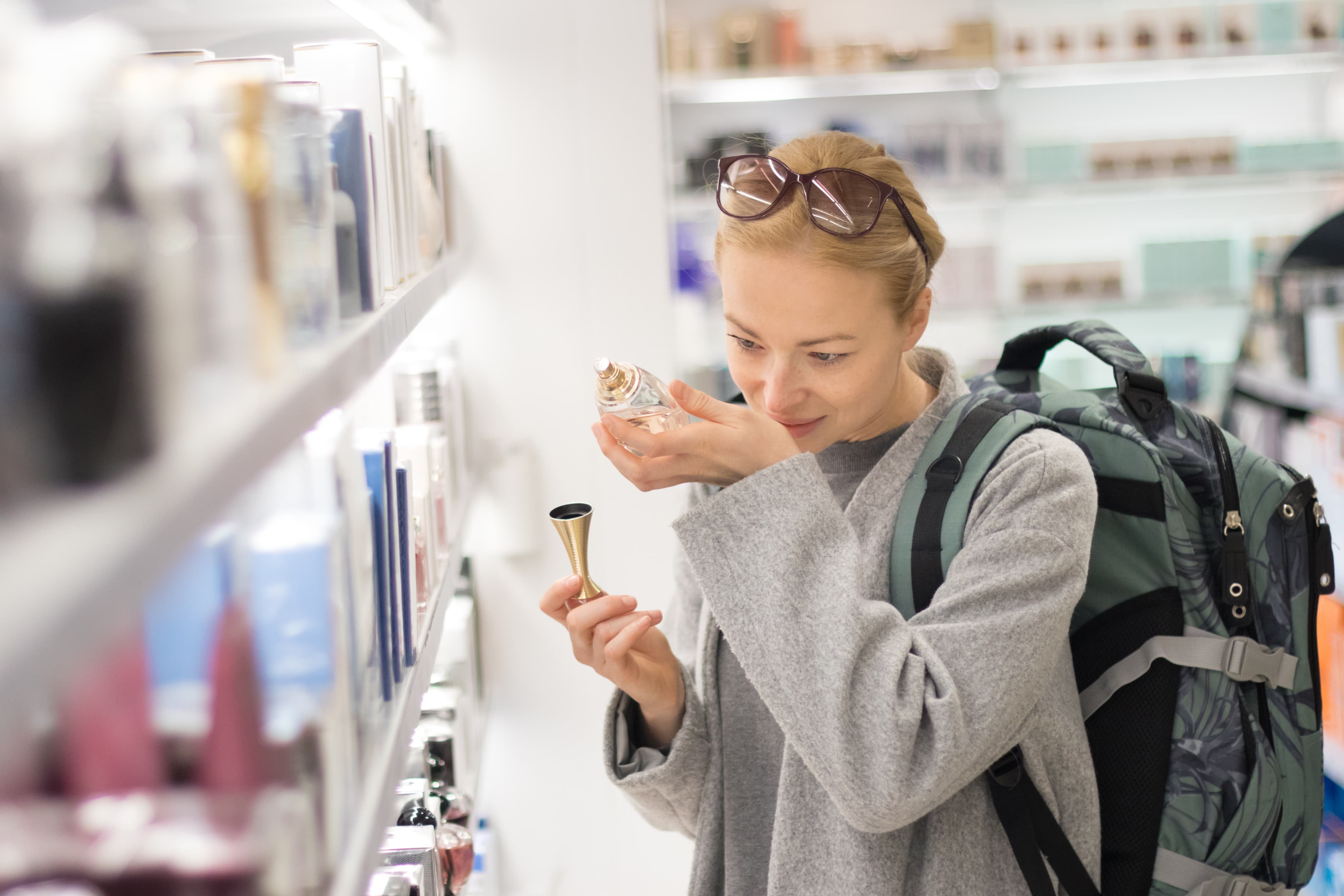 Woman smelling perfume in shop