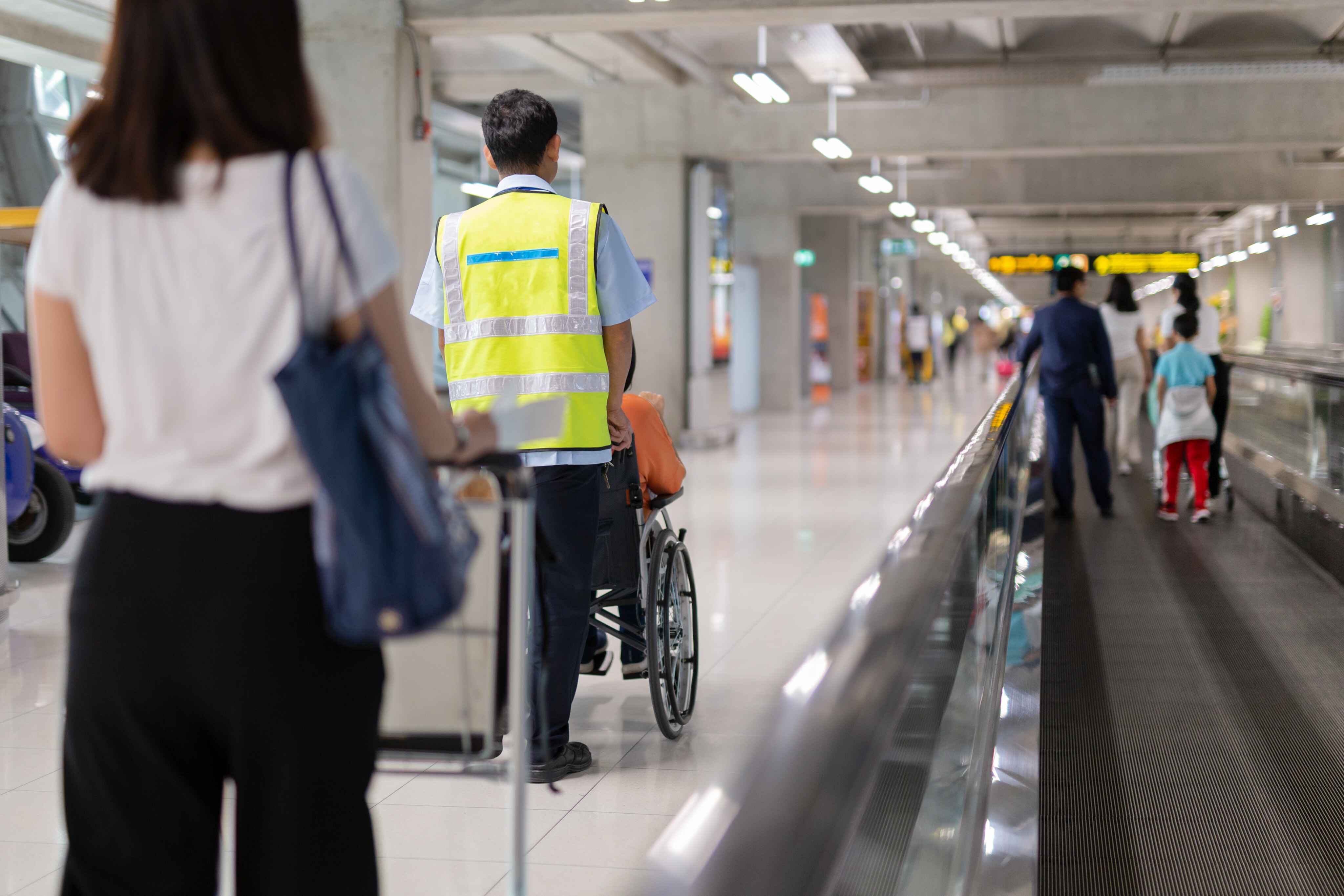 person being pushed through airiport in wheelchair