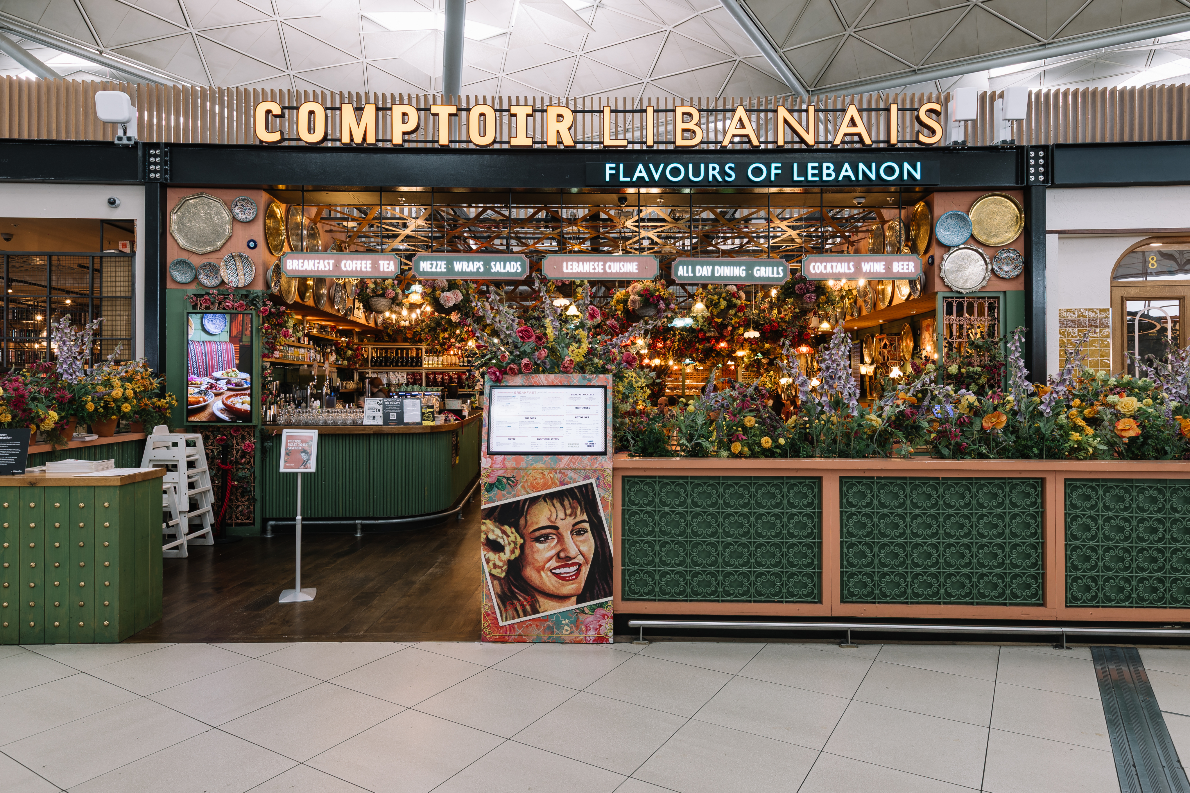 Colourful Lebanese restaurant entrance adorned with flowers and vibrant décor, offering mezze, drinks, and all-day dining.