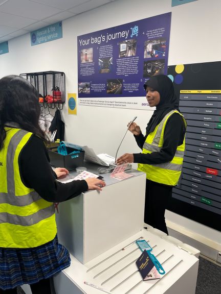 Image of 2 young girls pretending to work at the airport in security wearing high visibility jackets