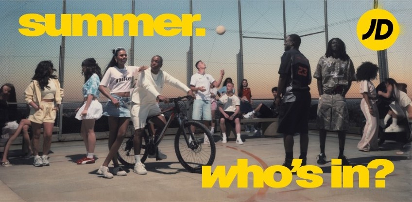 Group of young people enjoying summer activities on a rooftop court, featuring a bicycle and a volleyball, with bold yellow text overlay.